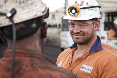 portrait photography small feature image of 2 miners talking at drift entrance.